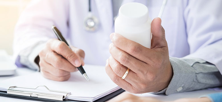 Chiropractor looking at paperwork and bottle